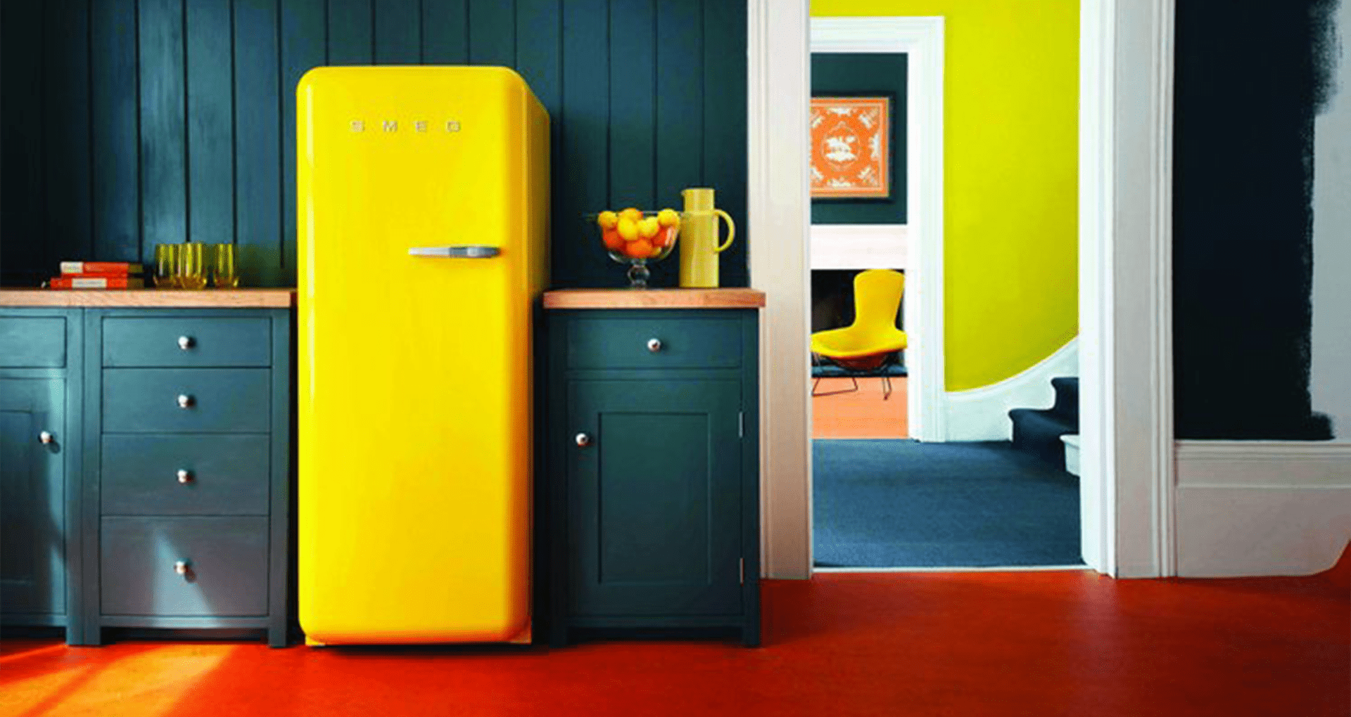 gelber Retro-Kühlschrank in grüner Küche