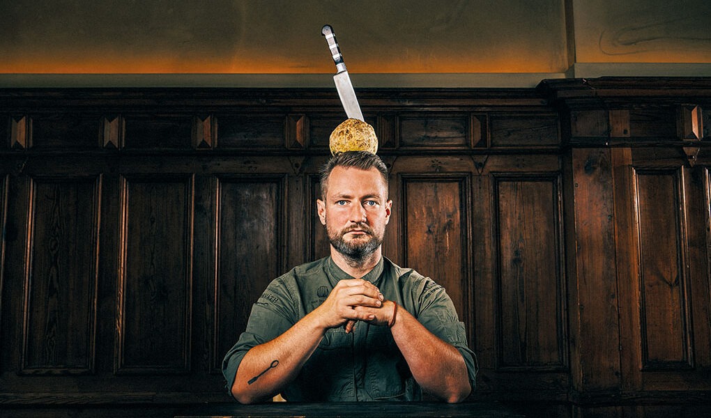 2-Sternekoch Sebastian Frank mit einem Sellerie und messer auf dem Kopf - Restaurant Horvath